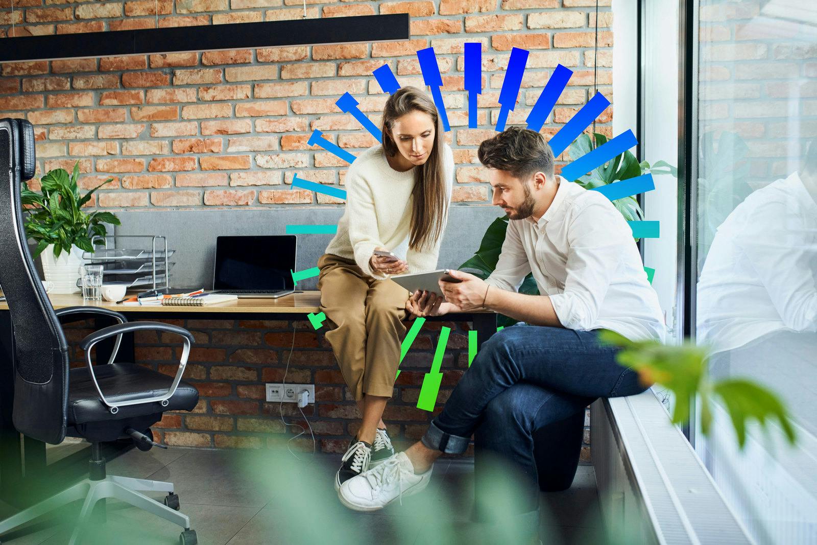 Businessman and businesswoman comparing ideas at on phone and digital tablet during casual meeting at startup office