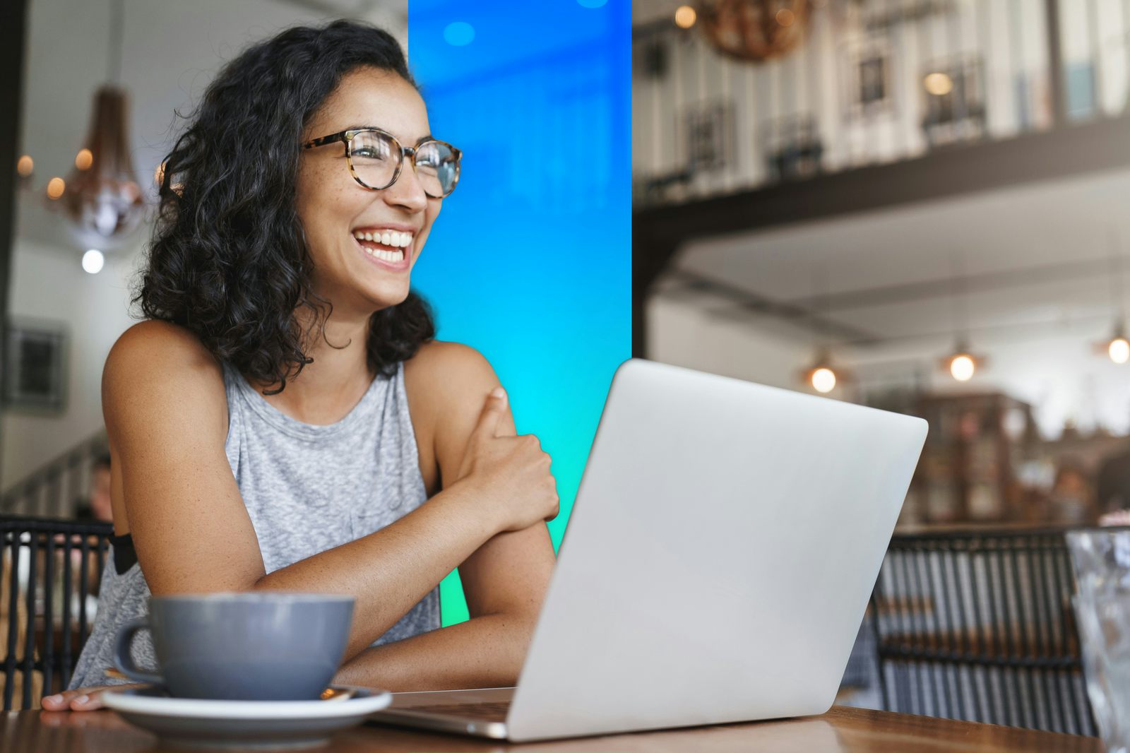 Woman laughing and working in front of a laptop